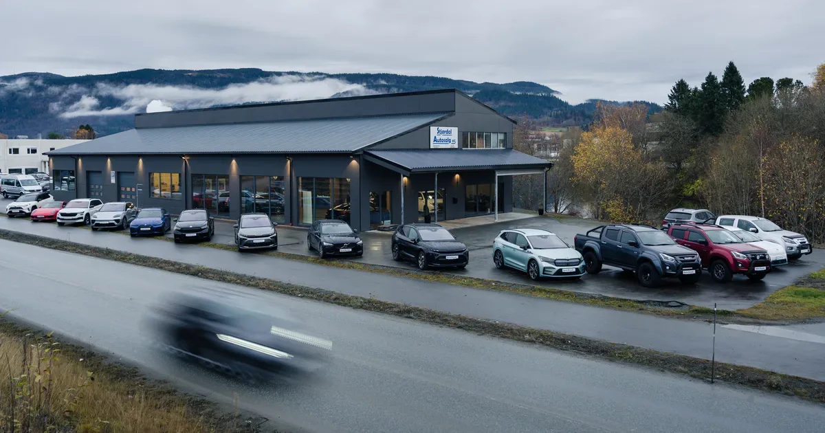 Bilrekke utenfor Stjørdal Autosalg med en bil i bevegelse i forgrunnen